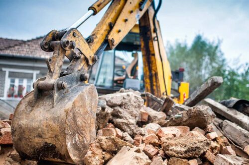 excavator-picking-up-debris-from-demolished-house-austin-tx